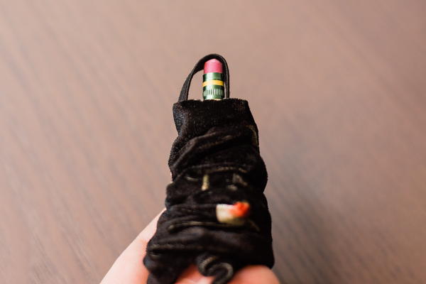 Image shows a pencil with the elastic being pushed out the end of the scrunchie tube.