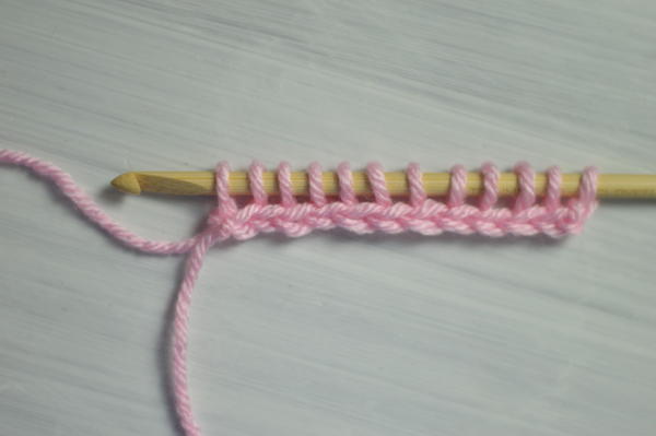 Image shows the first step in changing color at the beginning of the return pass in Tunisian crochet.