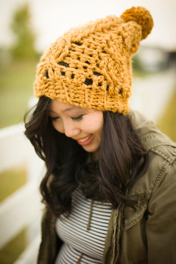 Image shows a woman wearing a Extra Cozy Crochet Beanie in bright yellow yarn.