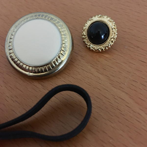 Image shows two shank buttons and a loop closure on a table.