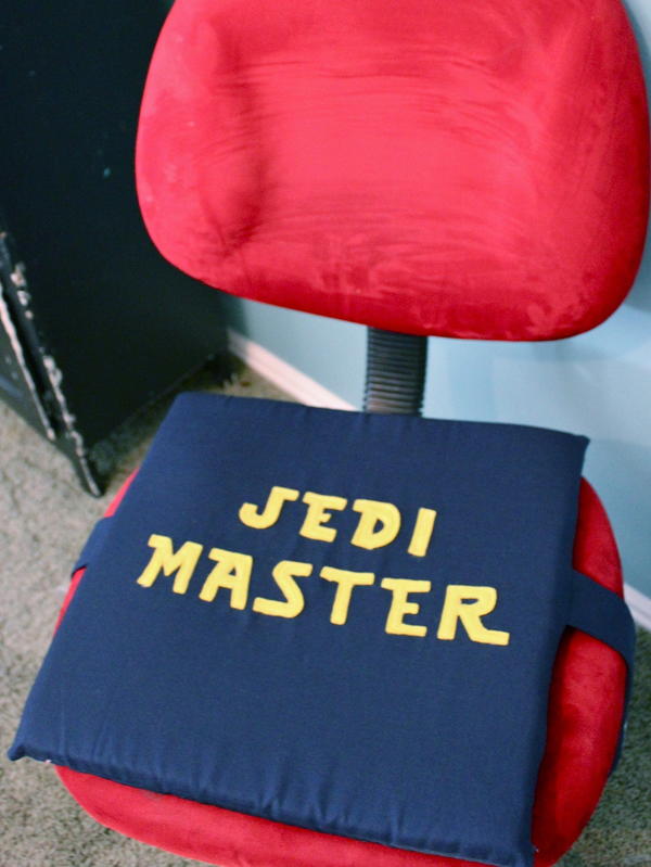 Image shows a red computer chair with the Jedi Master Star Wars Seat Cushion on the seat.