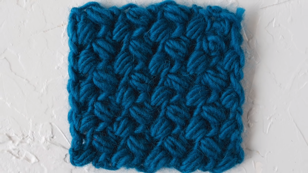 Image shows a bean stitch crochet swatch in peacock blue.