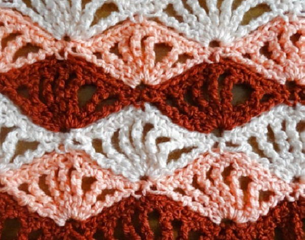 Image shows a close up of the quadruple shell stitch in white, pink, and red.