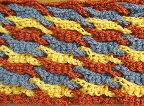 Image shows a close up of the single weave and link crochet stitch in multiple colors.