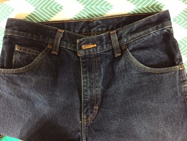 Image shows a close-up of a pair of jeans to visually explain bar tacks and rivets on jean pants.