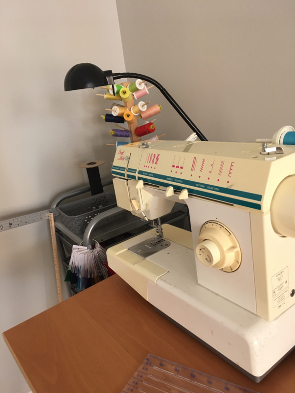 Image shows a sewing machine on a table.