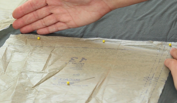 Image shows a tissue paper template after it has been pinned to fabric.