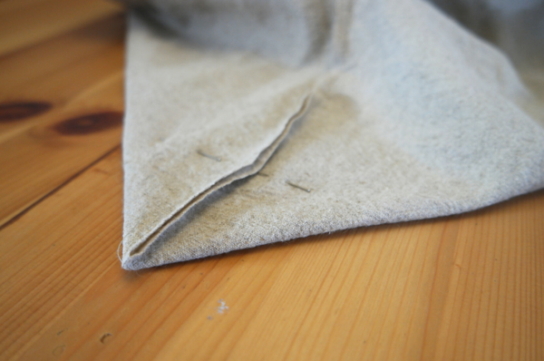 Image shows a corner of the bag pinned and sitting on a wood table.
