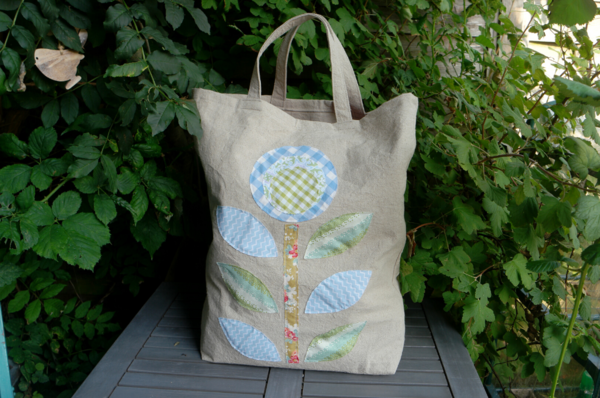 Image shows the Flower Applique Large Tote Bag sitting on a table outside.