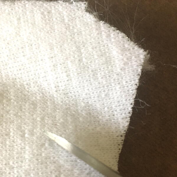 Image shows cutting out white faux fur fabric for the DIY Gnome Ornament.