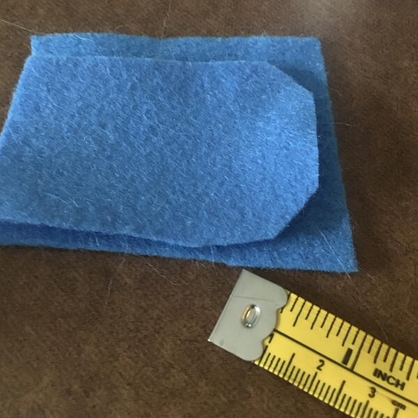 Image shows cut blue felt body pieces for the DIY Gnome Ornament.