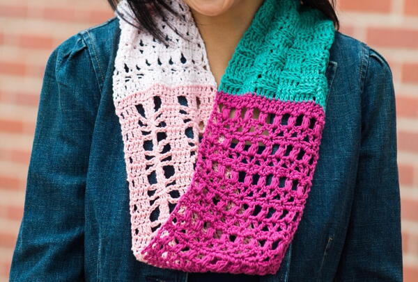 Image shows a close-up of a woman wearing the Southwestern Sunset Crochet Sampler Scarf.