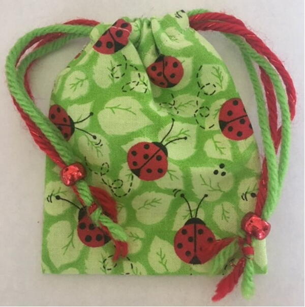 Image shows the finished DIY mini drawstring bag with embellishments.