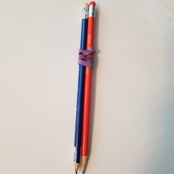 Two pencils attached with rubber band