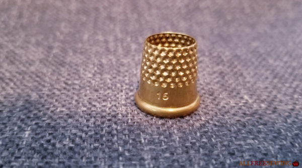 Image shows an open top thimble.