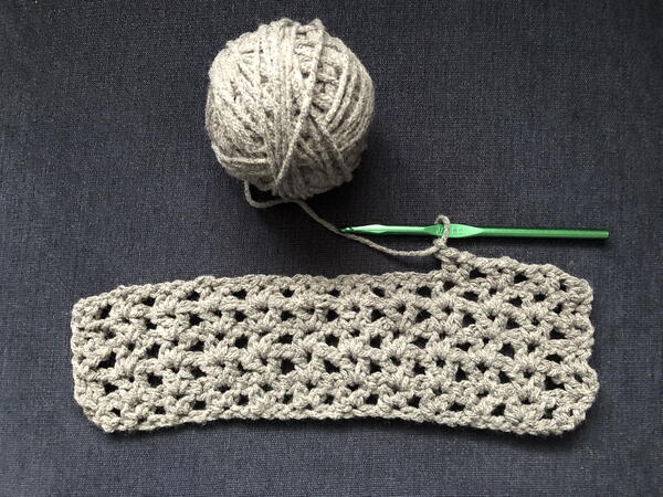 Image shows the start of a v-stitch blanket in gray.