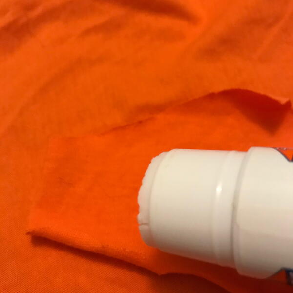 Image shows applying glue stick to fabric.