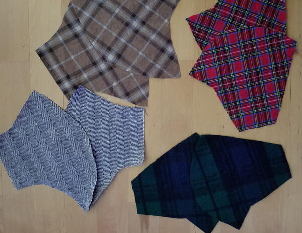 Image shows eight pieces of flannel cut in the shape of a mask template.