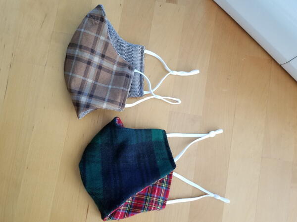 Image shows the finished flannel masks, folded, on a wood background.