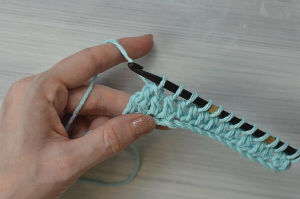 Image shows pulling through the first two loops on the hook for the Tunisian double crochet piece.