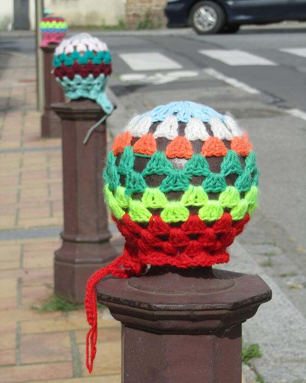 Example of yarn covered objects: street post crochet covers.