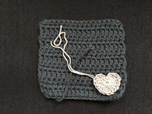 Image shows an example of a finished crochet square and a heart embellishment crocheted using a different weight of yarn.