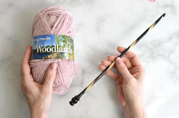 Image shows a Tunisian crochet hook and a ball of yarn.