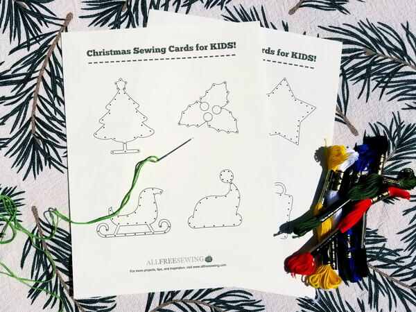 Image shows the printed sewing card sheet and cut out shapes that were sewn using different-colored embroidery floss. Three embroidery floss packages are below.