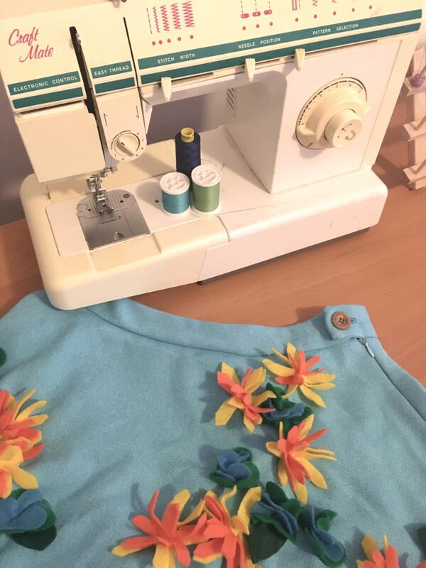 Image shows a sewing machine and a finished skirt adorned with 3D flowers.