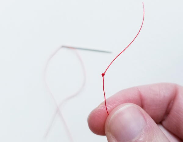 Threading a sewing needle: knot for sewing thread