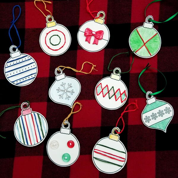 Image shows the printed sewing card sheet and cut out baubles that were sewn using different-colored embroidery floss. Three embroidery floss packages are below.