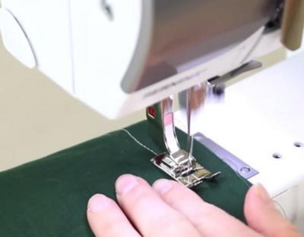 Image shows a close-up of someone sewing green fabric in a sewing machine without issues!