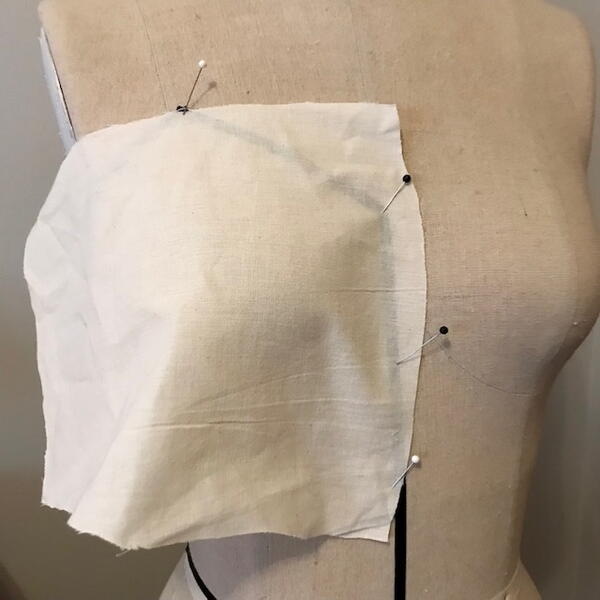 Mannequin with draping tape and fabric to start the draping and clothing design process.