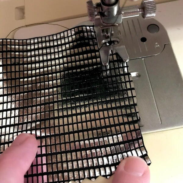Image shows a sewing machine attempting to sew a piece of decorative fabric.